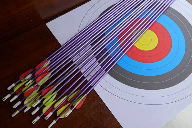 many arrows from a bows and target paper on the table